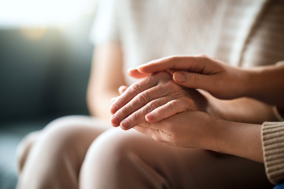 Close-up of two hands together, showing the fingers and palm of an adult hand
