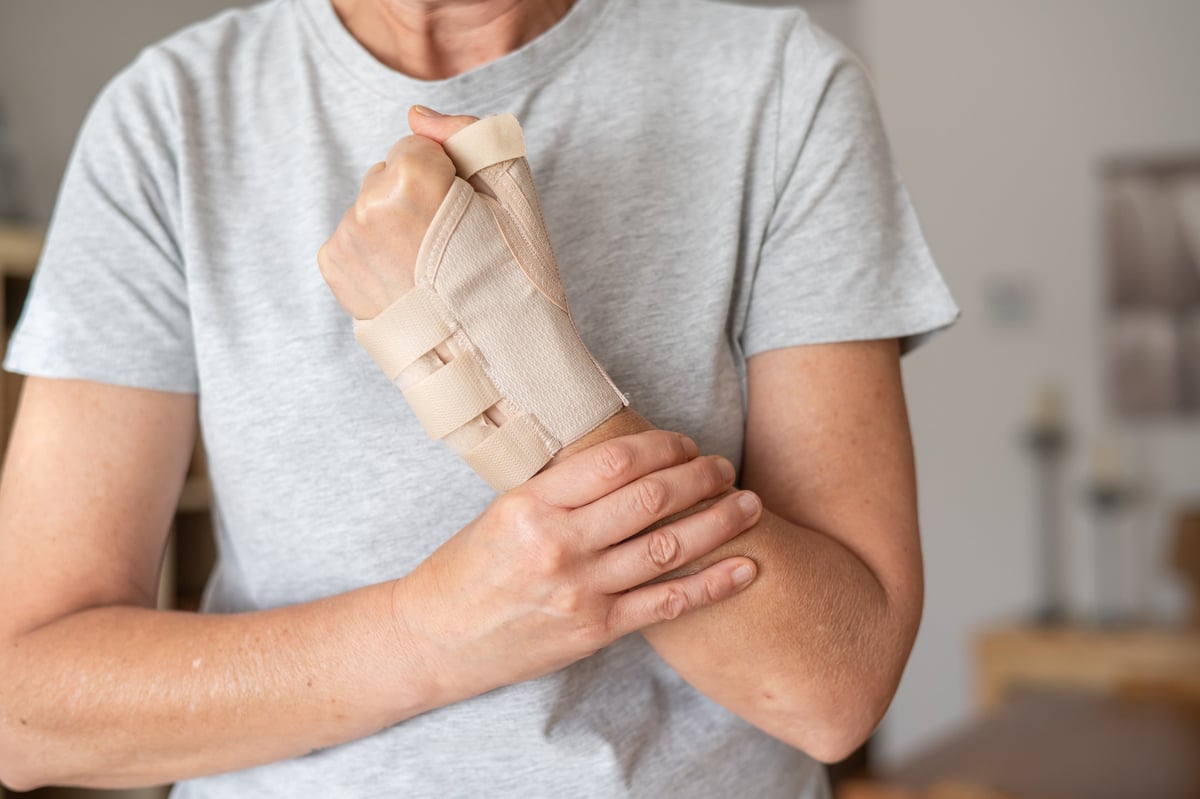 Person holding their painful wrist, illustrating wrist fracture pain and discomfort