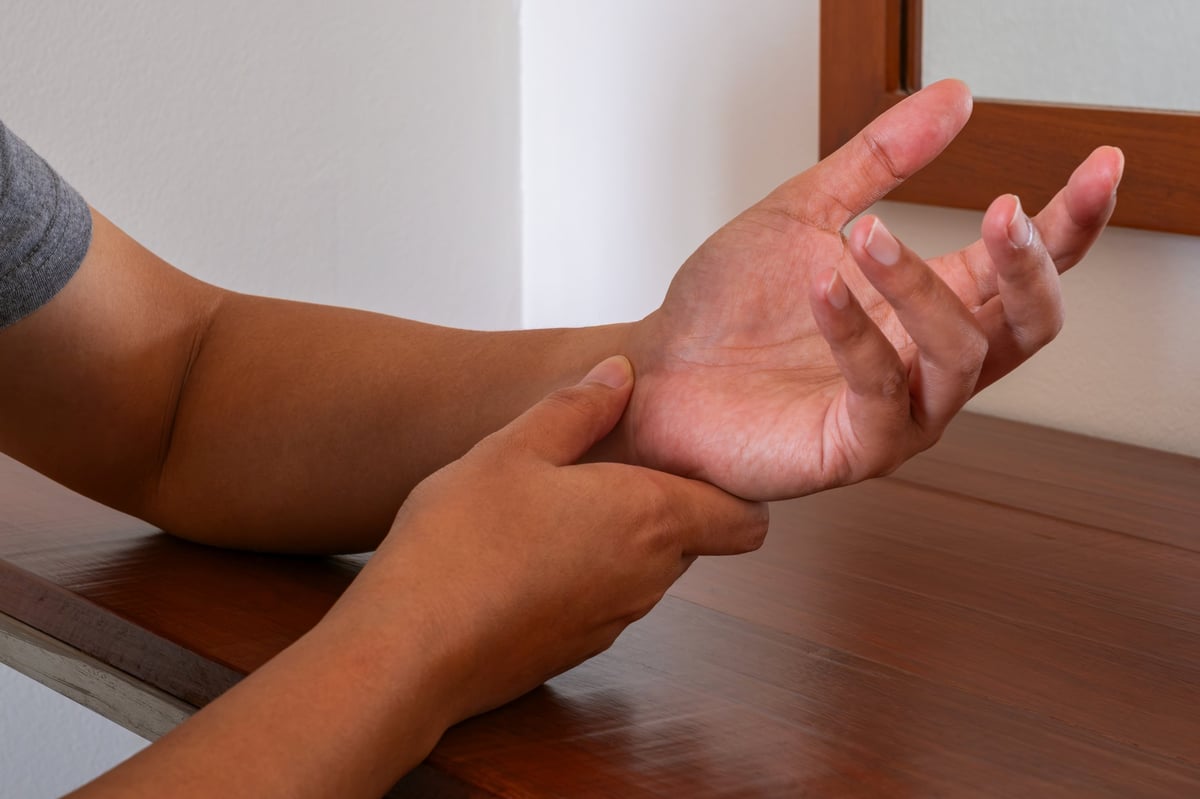 Man pressing a painful wrist, the small-finger side where TFCC injuries occur
